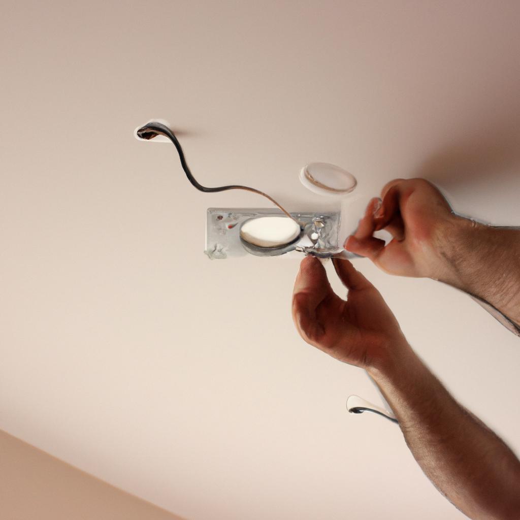 Person installing ceiling light fixtures