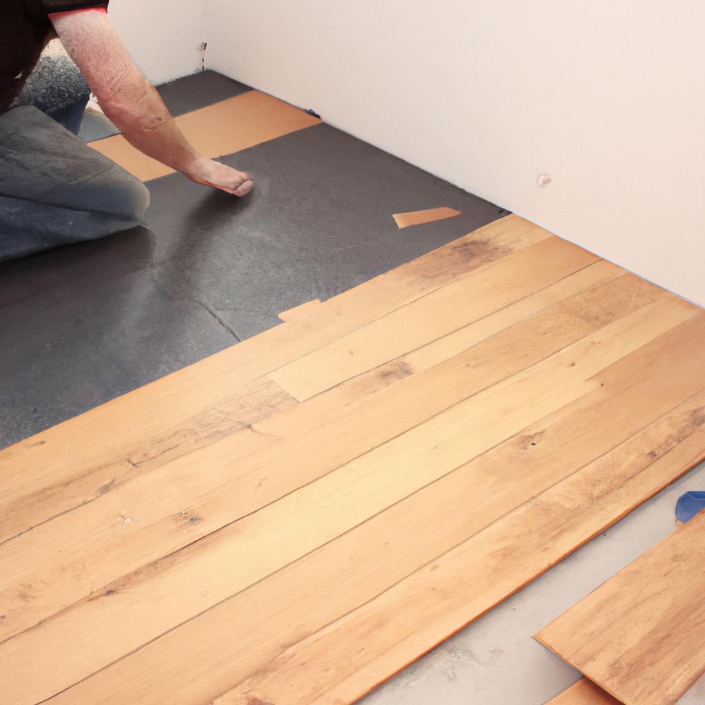 Person installing hardwood flooring indoors